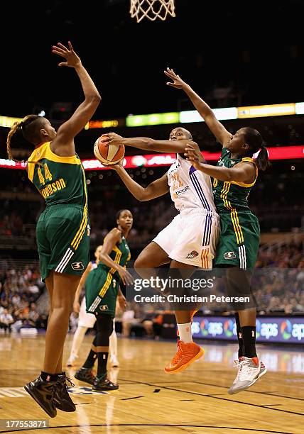 Charde Houston of the Phoenix Mercury attempts a shot against Ashley Robinson and Shekinna Stricklen of the Seattle Storm during the WNBA game at US...