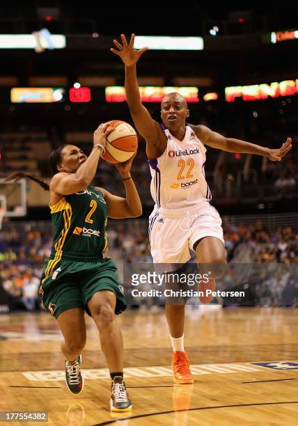 Temeka Johnson of the Seattle Storm drives to the basket against Charde Houston of the Phoenix Mercury during the WNBA game at US Airways Center on...