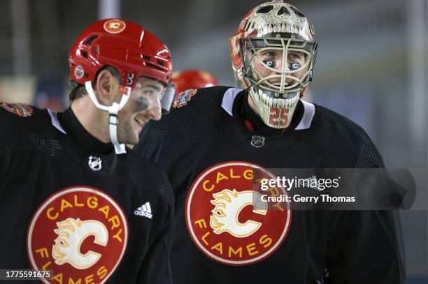 Dennis Gilbert and goaltender Jacob Markstrom of the Calgary Flames laugh during practice at Commonwealth Stadium on October 28, 2023 in Edmonton,...