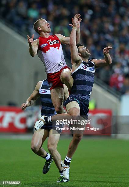 Ryan O'Keefe of the Swans marks the ball against Jimmy Bartel of the Cats during the round 22 AFL match between the Geelong Cats and the Sydney Swans...