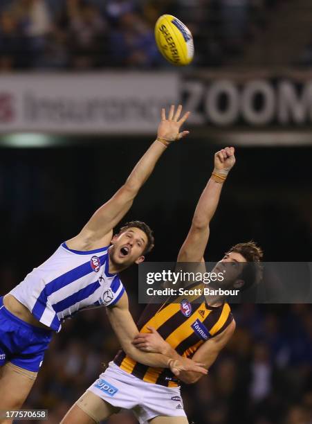 Ben Stratton of the Hawks and Aaron Black of the Kangaroos compete for the ball during the round 22 AFL match between the North Melbourne Kangaroos...