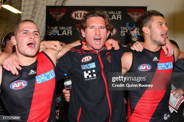 James Hird the coach of the Bombers sings the song with David Zaharakis and Tayte Pears after winning the round 22 AFL match between the Carlton...