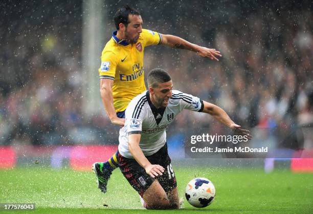 Adel Taarabt of Fulham and Santi Cazorla of Arsenal battle for the ball during the Barclays Premier League match between Fulham and Arsenal at Craven...