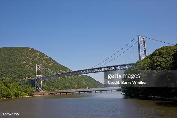 grey suspension bridge crossing water - bear mountain bridge stock pictures, royalty-free photos & images