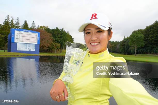 Mone Inami of Japan imitates the selfie as she poses with the trophy after winning the tournament following the final round of the TOTO Japan Classic...
