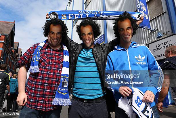 Supporters of Everton wear Roberto Martinez masks and Marouane Fellaini hair prior to the Barclays Premier League match between Everton and West...