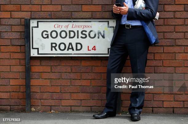 Fans stands beside the Goodison Road sign on his phone before the Barclays Premier League match between Everton and West Bromwich Albion at Goodison...