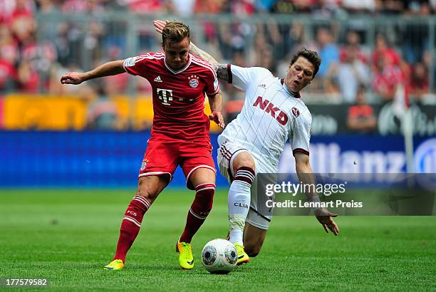 Mario Goetze of Muenchen challenges Daniel Ginczek of Nuernberg during the Bundesliga match between FC Bayern Muenchen and 1. FC Nuernberg at Allianz...