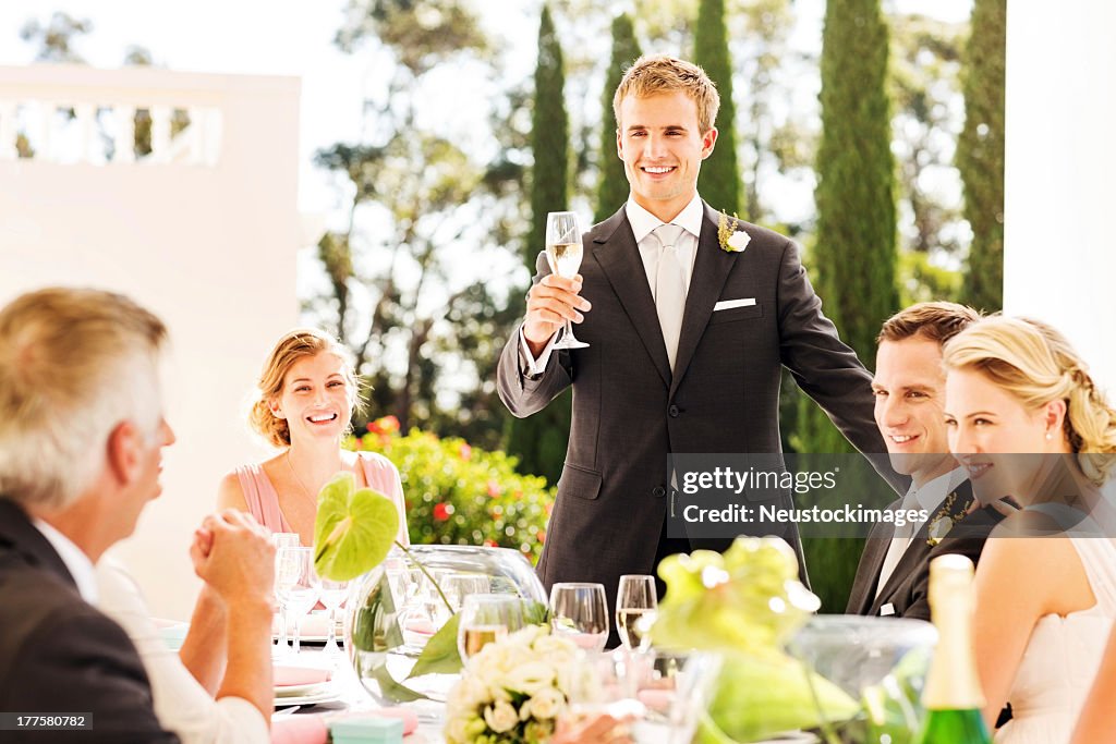 Best Man Raising A Toast During Wedding Reception