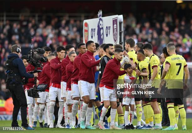 Players shake hands ahead of the English Premier League football match between Arsenal and Burnley at the Emirates Stadium in London on November 11,...