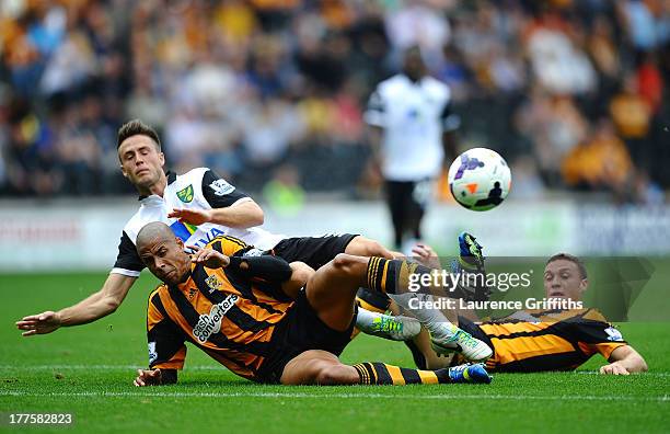 Ricky Van Wolfswinkel of Norwich City battles with James Chester and Curtis Davies of Hull City during the Barclays Premier League match between Hull...