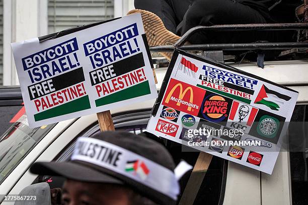 Demonstrators carry placards calling for the boycott of pro-Israel products and companies during a protest to show their solidarity with the...