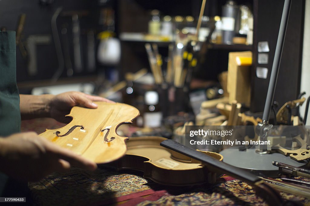 Man restoring violin in workshop