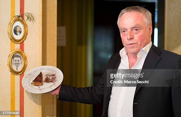 Carlo Campeol the present owner of Restaurant "Alle Beccherie" and son of Alba poses with a slice of Tiramisu on August 24, 2013 in Treviso, Italy....