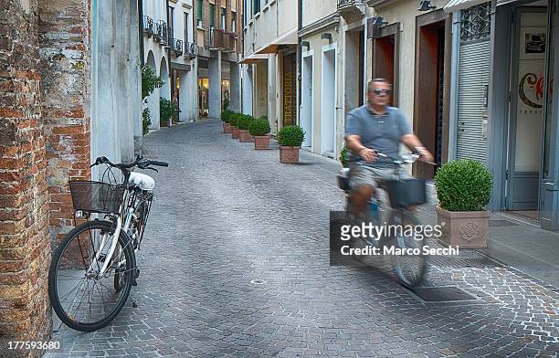 Ciclyst rides along a quiet street view in Treviso on August 24, 2013 in Treviso, Italy. Treviso claims that Tiramisu was invented in the 1960s by...