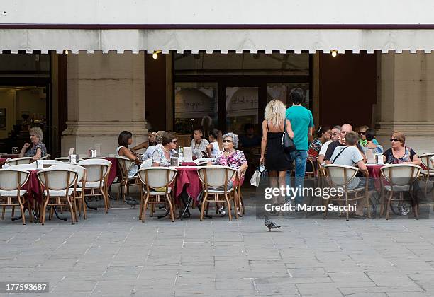 Customers sit at a cafe in the city centre on August 24, 2013 in Treviso, Italy. Treviso claims that Tiramisu was invented in the 1960s by Alba...