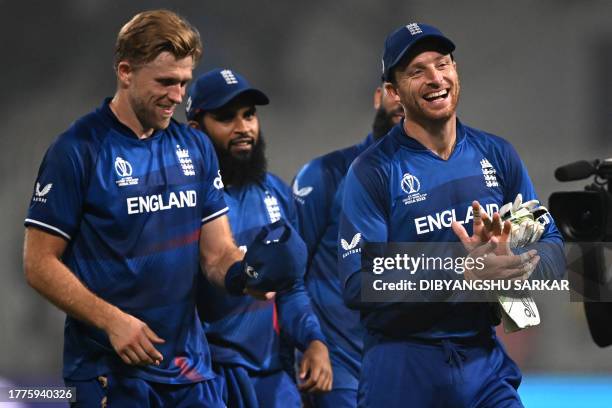 England's captain Jos Buttler with his teammates walk back to the pavilion after their win at the end of the 2023 ICC Men's Cricket World Cup one-day...