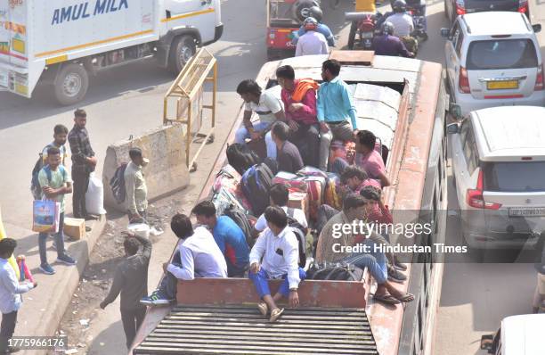 Passengers going home sitting on the roof of the bus on the occasion of Diwali on Lal Kuan Road on November 11, 2023 in Ghaziabad, India.