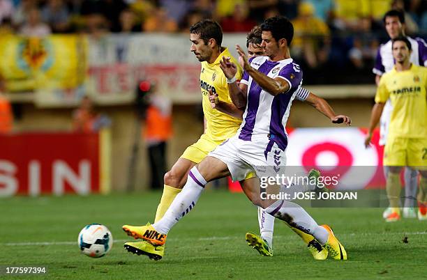 Villarreal's midfielder Cani vies with Valladolid's forward Javier Guerra during the Spanish league football match Villarreal CF vs Real Valladolid...