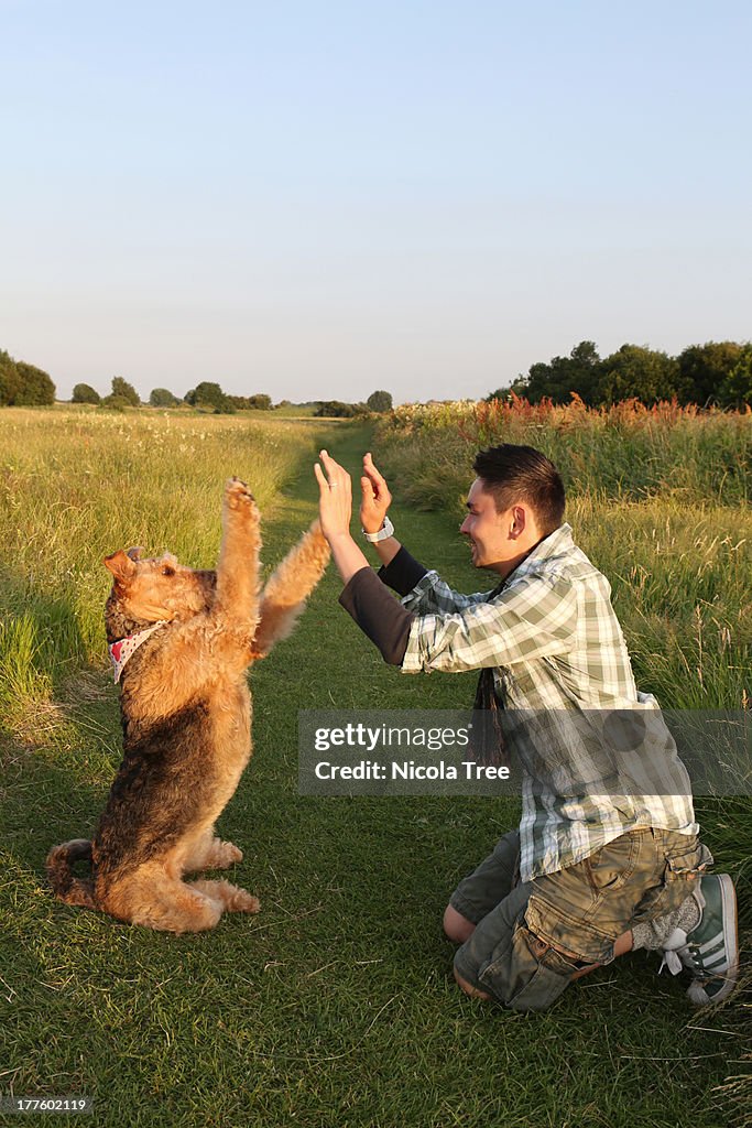 Male owner performing tricks with dog outside