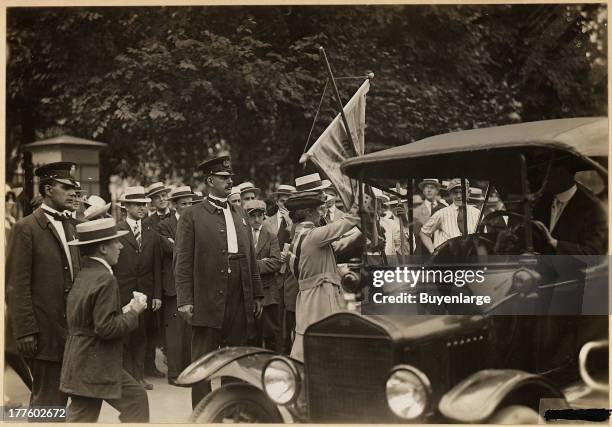 Suffragist arrested in front of the White House is seen being escorted into an auto which took her to the station house.
