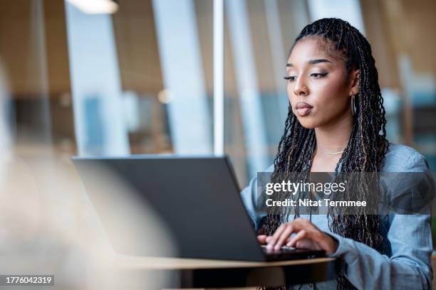 opportunities to work with large corporations as a software developer. young female african-american software developer using a laptop to design and develop software systems in a tech business office. - human life cycle stock pictures, royalty-free photos & images