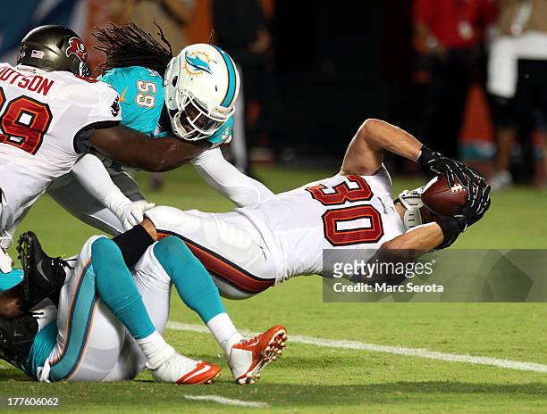 Running back Brian Leonard of the Tampa Bay Buccaneers scores a touchdown against the Miami Dolphins at Sun Life Stadium on August 24, 2013 in Miami...