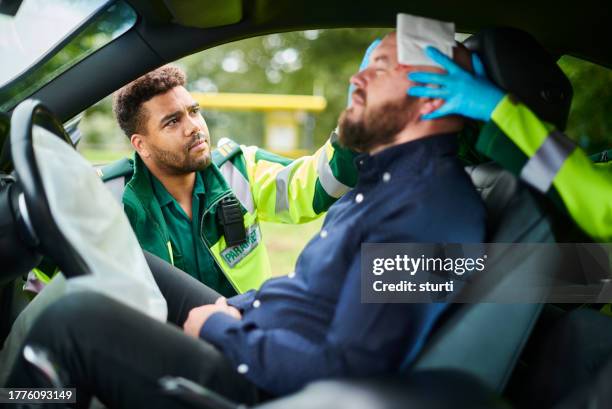 paramedics at traffic accident - ferido imagens e fotografias de stock