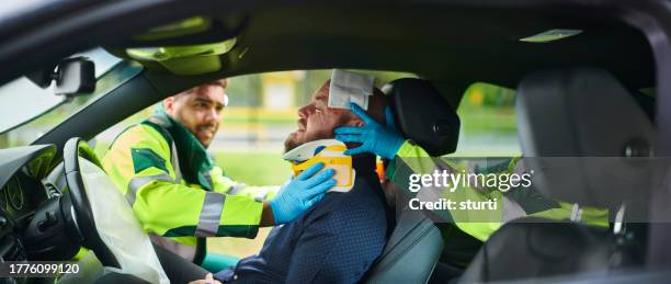 paramedics dealing with car crash - airbag stockfoto's en -beelden