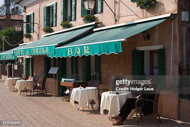 man with drink at ponte del diavolo restaurant - torcello stock pictures, royalty-free photos & images