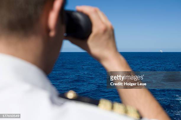officer looks through binoculars with cruise ship - officer military rank 個照片及圖片檔