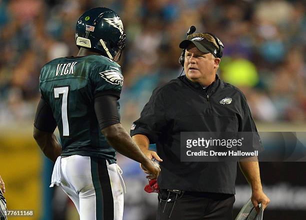 Michael Vick of the Philadelphia Eagles talks with coach Chip Kelly during the game against the Jacksonville Jaguars at EverBank Field on August 24,...
