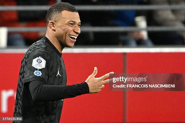 Paris Saint-Germain's French forward Kylian Mbappe celebrates after scoring his third goal during the French L1 football match between Stade de Reims...