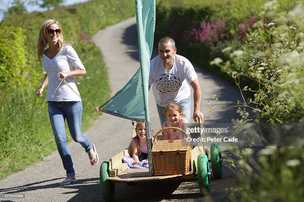 Family running with kart in country lane