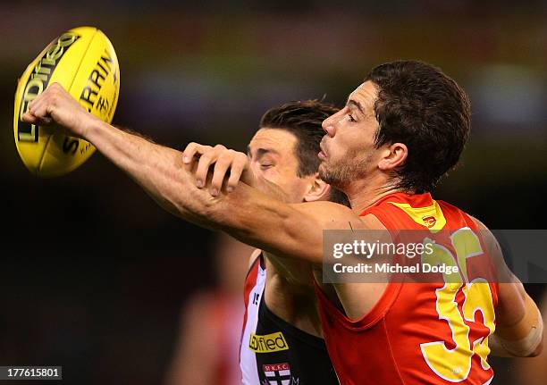 Michael Rischitelli of the Suns punches the ball away from Jack Steven of the Saints during the round 22 AFL match between the St Kilda Saints and...