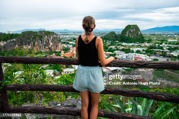 young woman admiring the view over the city of da nang in vietnam from a viewpoint. - danang stock pictures, royalty-free photos & images