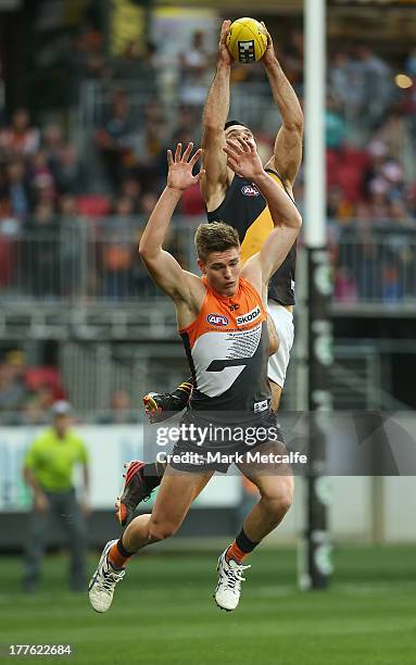 Troy Chaplin of the Tigers marks in front of Adam Tomlinson of the Giants during the round 22 AFL match between the Greater Western Sydney Giants and...