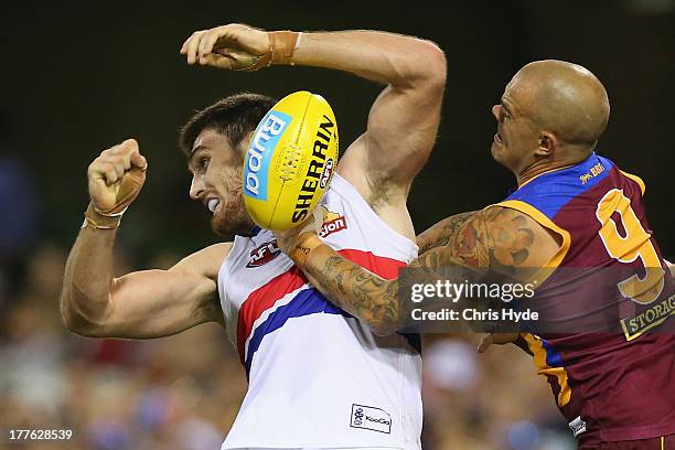 Tom Campbell of the Bulldogs is tackled by Ashley McGrath of the Lions during the round 22 AFL match between the Brisbane Lions and the Western...