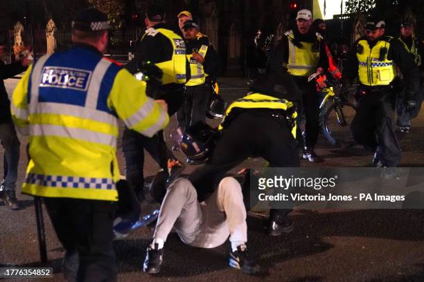 Counter-protester is detained police in Parliament Square in central London, after a pro-Palestinian protest march which was taking place from Hyde...