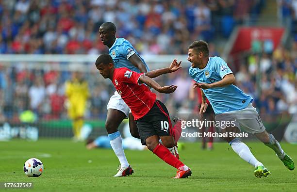 Fraizer Campbell of Cardiff attempts to break away from Yaya Toure and Javi Garcia of Manchester City during the Barclays Premier League match...