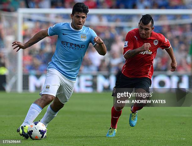 Cardiff City's Chilean midfielder Gary Medel vies with Manchester City's Argentinian forward Sergio Aguero during the English Premier League football...