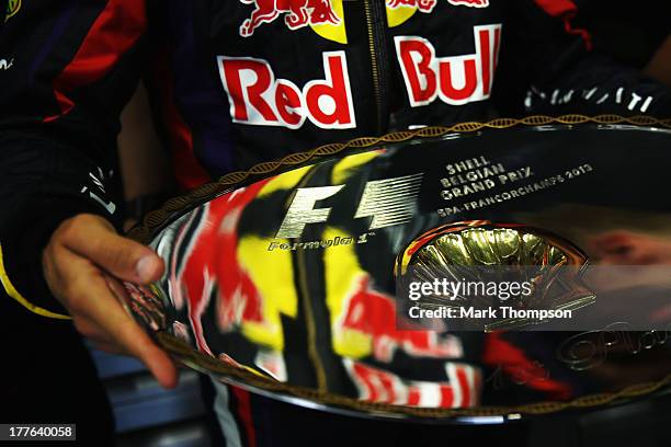 Sebastian Vettel of Germany and Infiniti Red Bull Racing celebrates in his team garage with the winners trophy following the Belgian Grand Prix at...