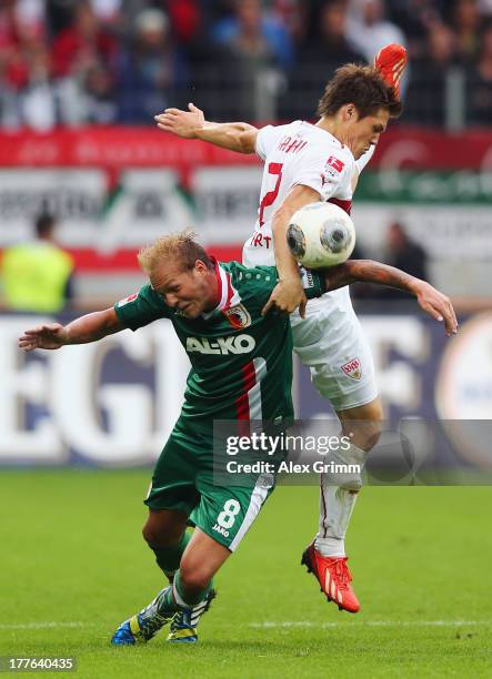 Raphael Holzhauser of Augsburg is challenged by Gotoku Sakai of Stuttgart during the Bundesliga match between FC Augsburg and VfB Stuttgart at SGL...