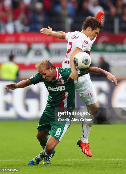 Raphael Holzhauser of Augsburg is challenged by Gotoku Sakai of Stuttgart during the Bundesliga match between FC Augsburg and VfB Stuttgart at SGL...