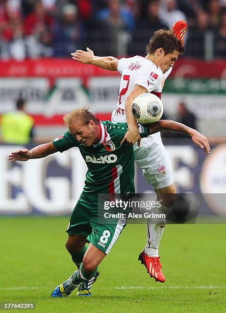 Raphael Holzhauser of Augsburg is challenged by Gotoku Sakai of Stuttgart during the Bundesliga match between FC Augsburg and VfB Stuttgart at SGL...