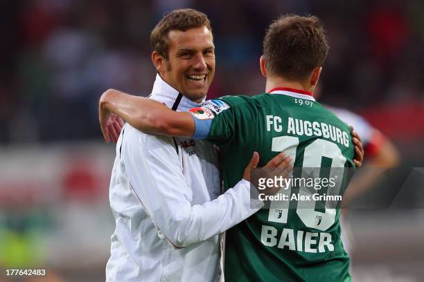 Head coach Markus Weinzierl of Augsburg hugs Daniel Baier after the Bundesliga match between FC Augsburg and VfB Stuttgart at SGL Arena on August 25,...