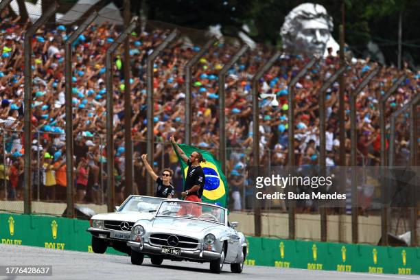 Lewis Hamilton of Great Britain and Mercedes and George Russell of Great Britain and Mercedes wave to the crowd on the drivers parade prior to the F1...