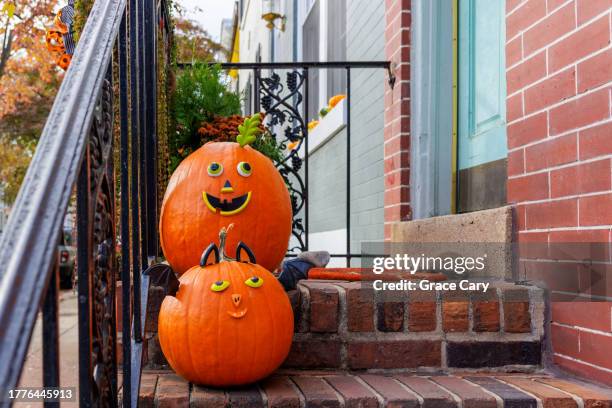 decorated pumpkins adorn front stoop of townhouse - doorstep stock pictures, royalty-free photos & images