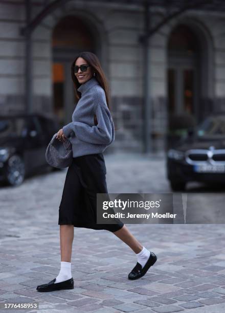 Jill Asemota seen wearing Jacques Marie Mage black sunglasses, Dorothee Schumacher grey wool knit sweater, Dorothee Schumacher black silk midi skirt,...