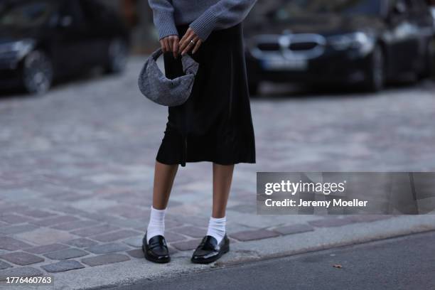 Jill Asemota seen wearing Dorothee Schumacher grey wool knit sweater, Dorothee Schumacher black silk midi skirt, Bottega Veneta grey suede leather...